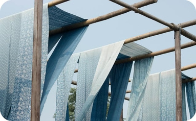 Lengths of fabric hanging to dry, illustrating textile development